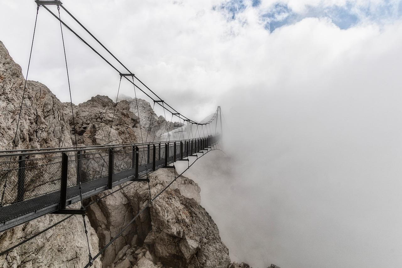 Brücke in den Bergen führt in den Nebel. Themenübergänge moderieren